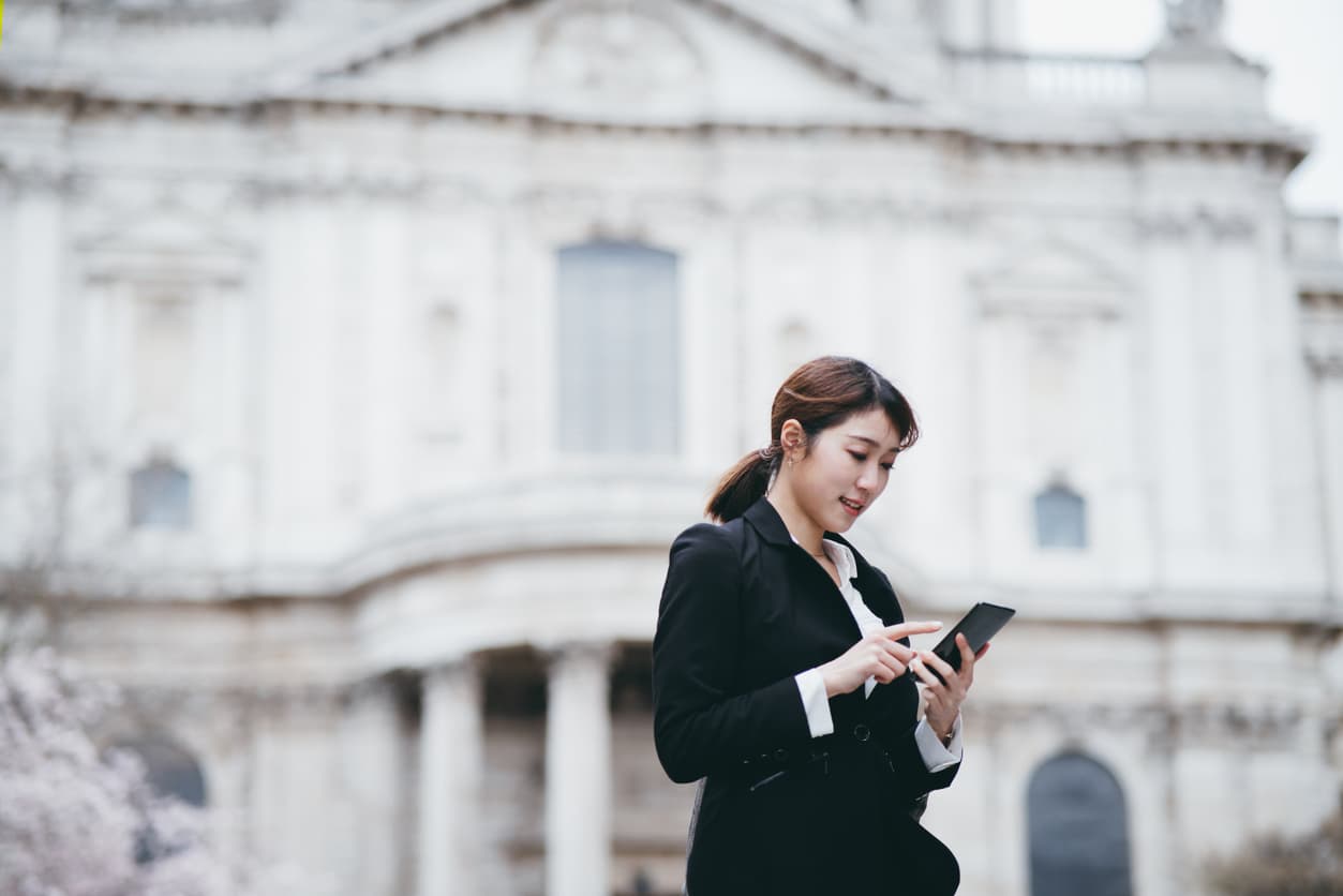 Expat woman in the United Kingdom checking her bank account on her phone