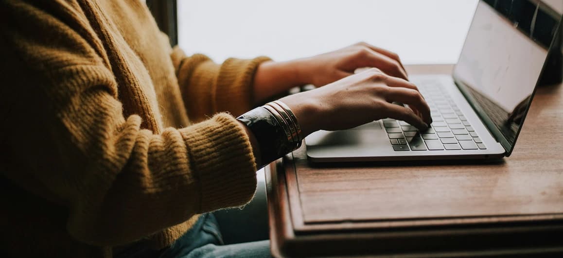Small business owner sitting at a desk with a laptop and paperwork, opening a U.S. business bank account online.