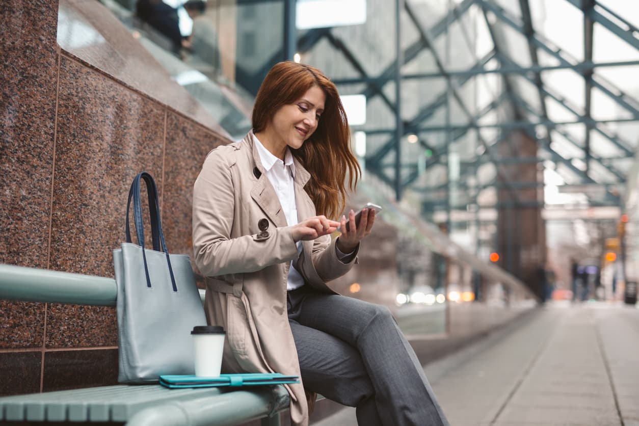 Young woman using her phone to check her bank account in Vancouver, Canada